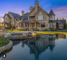 a large house with a pond in front of it and landscaping around the pool area