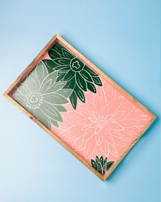 a pink and green flowered tray on a blue background