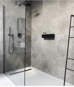 a walk in shower sitting next to a white bath tub under a faucet