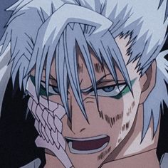 an anime character with white hair and green eyes talking on a cell phone in front of him