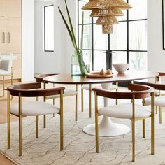 a dining room table with chairs and a vase on the table in front of it