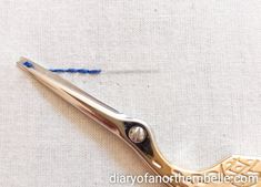 a pair of scissors that are sitting on a piece of cloth with thread in it