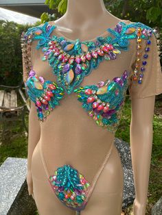 a mannequin wearing a bodysuit with colorful beads and jewels on it's chest