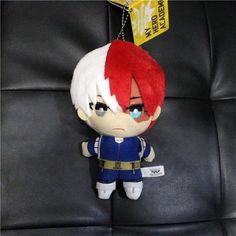 an anime character keychain hanging on a black leather chair with a tag attached to it