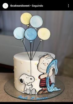 a birthday cake decorated with balloons and a cartoon character