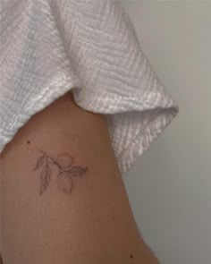 a small tattoo on the back of a woman's left arm, with an olive branch