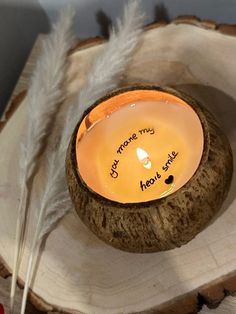 a candle that is sitting on top of a tree stump with some writing on it