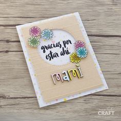 a handmade card with flowers and the words congratulations written in spanish, on top of a wooden table