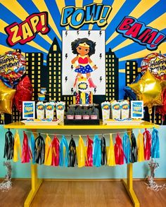 a party table with balloons, streamers and decorations