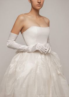 a woman in a white dress and gloves