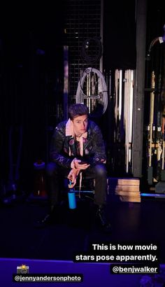 a man sitting on top of a chair next to a blue cup in front of him