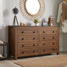 a dresser with drawers and a mirror on the wall next to it in a room