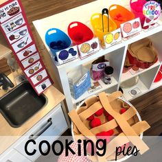 a child's play kitchen with cooking pies on the counter and in front of it