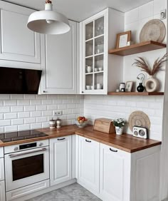 a kitchen with white cabinets and wooden counter tops