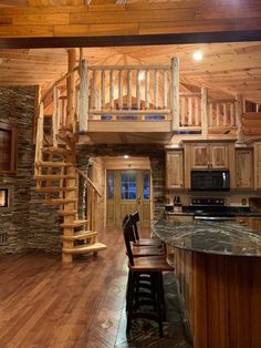 a kitchen with wooden floors and stairs leading to the upper floor, along with a spiral staircase