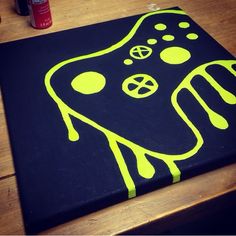 a black canvas with neon yellow designs on it sitting on top of a wooden table