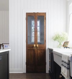 a kitchen with white walls and wooden doors