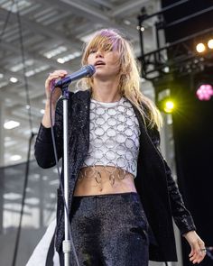 a woman standing on top of a stage holding a microphone