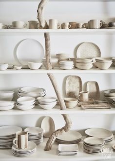 the shelves are filled with dishes and plates