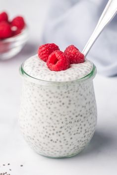 a glass jar filled with chia pudding topped with raspberries