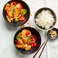 two bowls filled with chicken, peppers and cashews next to chopsticks