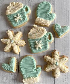 decorated cookies in the shape of teapots and snowflakes on a table