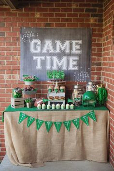 a game time dessert table is set up with green and white decorations on the table