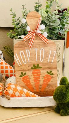 a wooden sign that says hop tot with carrots on it next to other decorations