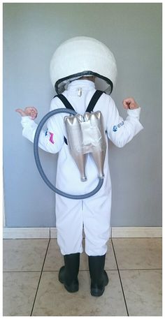 a little boy dressed up as a doctor holding a stethoscope in front of his face