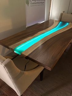 a modern dining table with blue lights on the top and side panels that glow in the dark