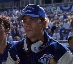 two men in blue and white baseball uniforms standing next to each other at a game