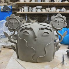 a clay sculpture is being made in the shape of a head with flowers on it