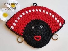 a crocheted coin purse with a black face and white polka dots on it