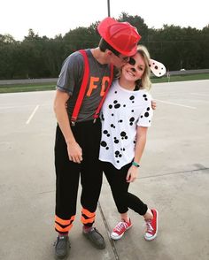 a man and woman in matching outfits pose for a photo on an empty basketball court