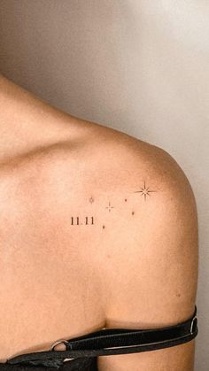 the back of a woman's shoulder with small stars and lines on it,