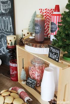 a table topped with cookies next to a chalkboard and christmas trees on top of it