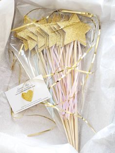 a bunch of straws with gold stars on them sitting in a plastic wrapper