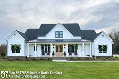 a large white house sitting on top of a lush green field