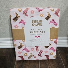 an artisan weave sheet set with pink and brown shoes on the front, sitting on a wood floor