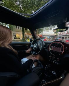 a woman sitting in the driver's seat of a car