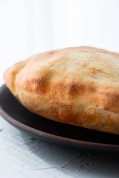 a piece of bread sitting on top of a black plate