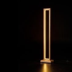 a light that is sitting on top of a wooden stand in the middle of a dark room