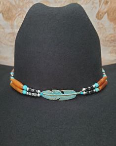 Western Cowboy Hat band with Black or GoldenAmber Buffalo Horn or Black/White Hairpipe Beads and either silver or turquoise feather centerpiece, hematite and silver plated beads.  Turquoise Feather has turquoise color accent beads and Silver Feather has Hematite Accent beads (see pictures).  Includes adjustable deerskin tie in back.  Measures approximately 22.5" in length.  Designed and Handmade by me!  Shown on a size 7 hat - Hats are not included.     Can be made with the following Hairpipe Beads:  Black Horn, Black/White, GoldenAmber, Red, Bone, or Antique Bone (just put color in comments) or message me. Tie in back can be:  Black, Natural, Rusty Brown or Brown (list under Personalization). See my other listings for over 160 different handmade designs:  https://www.etsy.com/shop/BlueEye Adjustable Hat Bands With Feathers For Festivals, Adjustable Feather Hat Bands For Festivals, Bohemian Adjustable Hat Band With Feathers, Adjustable Bohemian Necklace For Rodeo, Adjustable Silver Hat Bands For Festivals, Adjustable Feather Festival Jewelry, Adjustable Feather Jewelry For Festivals, Burned Hats, Cowboy Hat Band