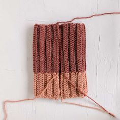 an orange and pink knitted object on a white surface