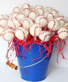 a blue bucket filled with white and red baseballs