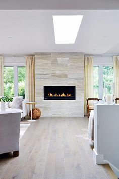 a living room filled with furniture and a fire place in the middle of it's wall