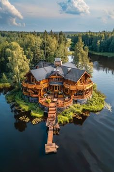 an aerial view of a large house on the water with a dock in front of it