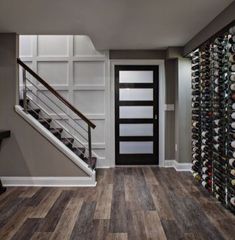 a wine rack is next to the stairs in this entryway with wood flooring