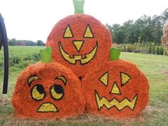 three pumpkins made out of hay with faces drawn on them