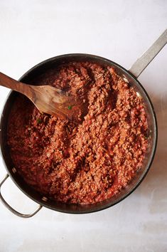 a pot filled with meat and a wooden spoon